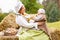 Peasant mother with little baby in summer playing on haystack in the field