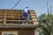 a peasant, a villager repairs the disassembled roof of a country house