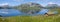 Peat roofed hut on Lake Stavatn with mountains reflected in it.