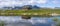 Peat roofed hut on Lake Stavatn with mountains reflected in it