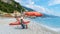 Pebble beach Monterosso vacation Chairs and umbrellas on the beach of Cinque Terre Italy.