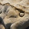 Pebble on hole in geologic rock formation on the beach, Asturias, Spain