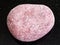 pebble of pink Arkose sandstone on dark background