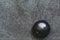 Pebble polished shungite tumbled stone on a black background with blank space