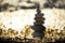 Pebble pyramid on the beach. sparkling bokeh from the water in the background.