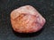 pebble of rose quartz stone on dark background