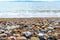 Pebble stones on beach and sea water. Glyfada Beach in Athens. Famous municipal beach after a thunderstorm. Winter landscape.