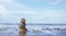 Pebble tower by seaside with blurry seascape, Stack of Zen rock stones on the sand, Stones pyramid on the beach symbolizing,