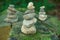 Pebble towers in a forest. Balanced stones in a pile on the wooden background covered with moss