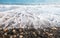 Pebbles in the beach with soft milky sea water