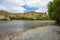 Pebbles on Hurunui River Mouth under blue cloudy sky in South Island, New Zealand