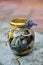 Pebbles and water in a jar with a flower branch on stone blurred background