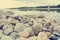 Pebbly lake shore on a summer afternoon, retro style