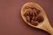 Pecan nut close-up in spoon on bright brown background.Healthy fats.Heap shelled Pecans nut closeup. Ingredient of the
