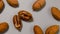 Pecan nuts in a hard shell with cracks on a gray background.