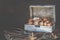 Pecan nuts and macadamia walnuts in a box with pegs for nuts on a wooden background. Copy space