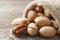 Pecans spill out of a bag on a wooden table, close-up. Peeled, in a shell