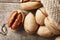 Pecans spill out of a bag on a wooden table, close-up. Peeled, in a shell