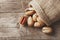 Pecans spill out of a bag on a wooden table, close-up. Peeled, in a shell