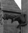 Peculiar humanized animal gargoyle standing on the cloister