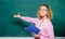 Pedagogue hold book and explaining information. Teacher explain hard topic. Woman school teacher in front of chalkboard