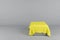 Pedestal in the form of a cube covered with yellow cloth. 3D rendering