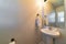 Pedestal sink and mirror against white wall of minimalist residential bathroom