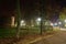 Pedestrian alley, benches and medieval tower at night illuminated with LED lamps