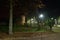 Pedestrian alley, benches and medieval tower at night illuminated with LED lamps