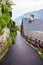 Pedestrian, asphalt road near old vintage wooden roofs of houses by the lake in Hallstatt, Austria