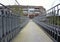 pedestrian bridge over suburban road and curved continuation of wooded recreational trail