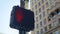 Pedestrian crossing light hanging on traffic pole on sidewalk pavement closeup.