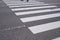 Pedestrian crossing with road marking. White lines on the dark a