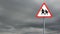 Pedestrian crossing sign board post against dark clouds in the sky