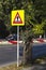 The pedestrian crossing sign on a bright yellow background made of a reflective fluorescent film for better visibility. Traffic