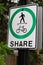 A pedestrian cyclist share path sign that has been vandalized to show a skateboarder instead