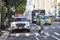 Pedestrian with a dog on zebra crossing with NYPD vehicle parked on a street by the Central Park.