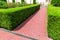 Pedestrian footpath made of red tiles with a drainage grid.