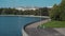 Pedestrian girls walking on river embankment. City Park with broadcast tower.