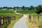 Pedestrian road through the fields at the Flemish countryside in summer