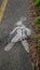 Pedestrian symbol painted white on a dedicated passage on ruined asphalt