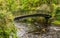 A pedestrian visitor`s bridge over river Eachaig in Benmore Botanic Garden, Scotland