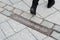 Pedestrian walking across commemorative plaque for Berlin Wall