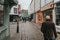 Pedestrian walking along cobblestoned street, with shops around it, and traditional architecture in the village of Canterbury,