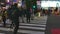 Pedestrians cross at Shibuya Crossing in evening