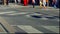 Pedestrians Crossing Downtown City Street.  People Walking Across Busy Urban Road Intersection.  Crosswalk