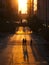 Pedestrians crossing street at sunset