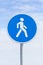 Pedestrians Path. Blue round road sign under cloudy sky, close up