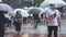 Pedestrians walk across street holding their umbrella on a rainy day in Fukuoka, Japan