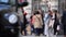 Pedestrians walking on trottoir near traditional London bus station